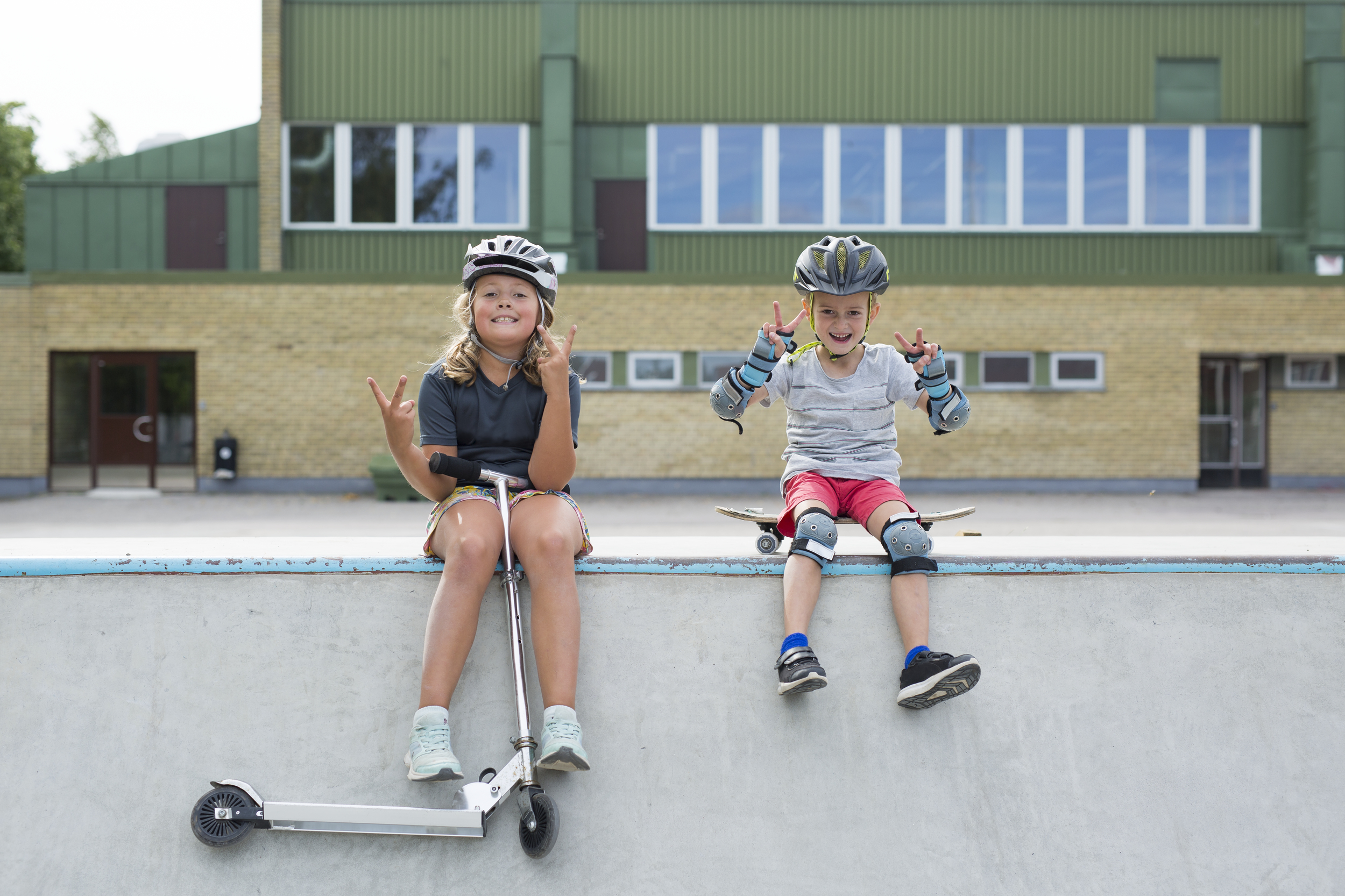 Två barn sitter på en skateramp